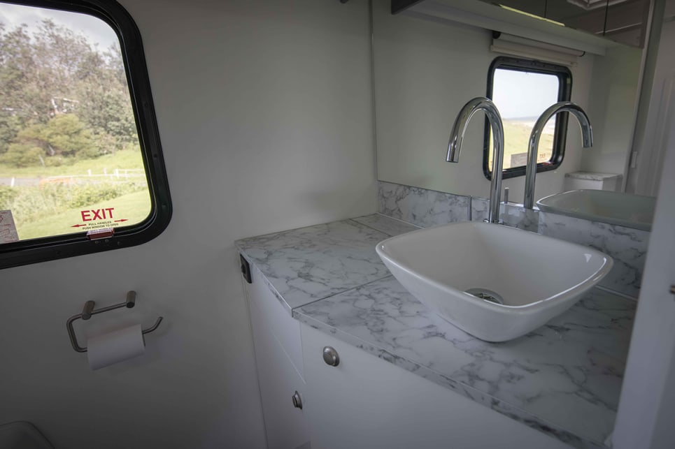 The bathroom features a shower, toilet, raised porcelain basin on the vanity and towel hooks.