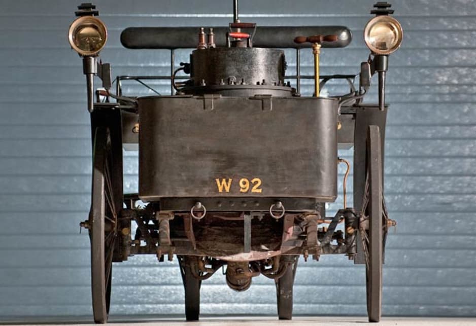 The head of steam pressure drives two engines, one for each of the front wheels, and the car is steered by a spade-handled tiller.
