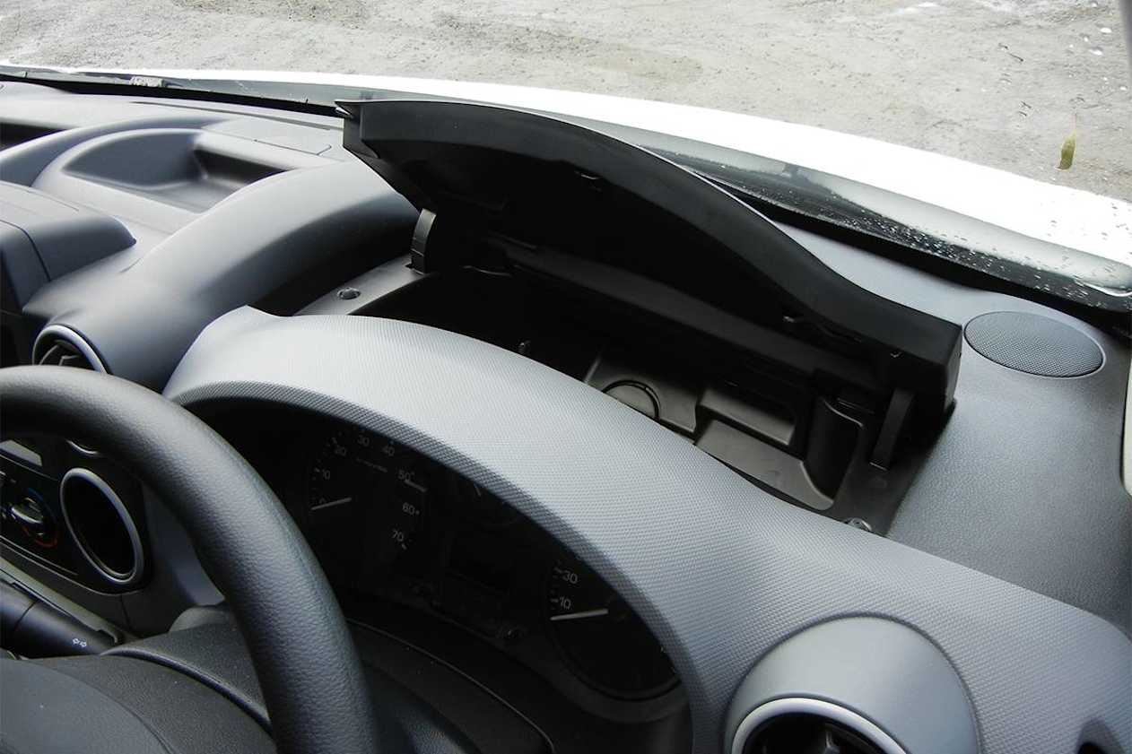 There’s a large lidded compartment and two open bins set into the dash-top. 