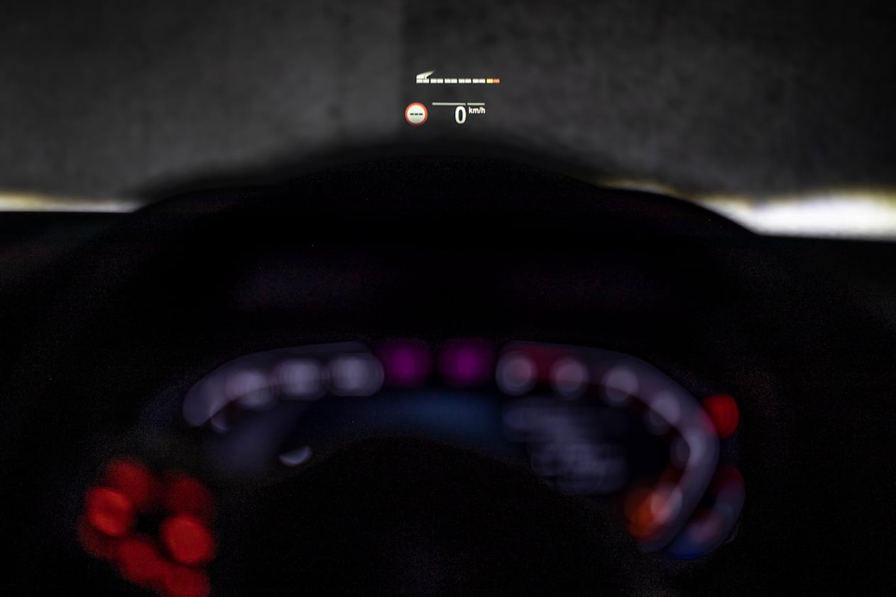 The head-up display shows speed, engine data, road information, and navigation instructions.