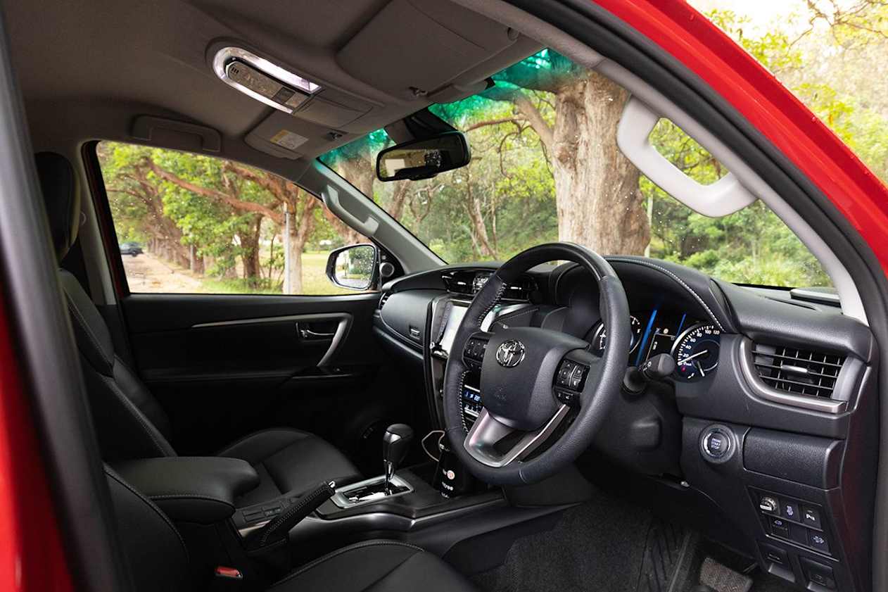 The Fortuner has a leather-accented interior and a woodgrain look steering wheel.