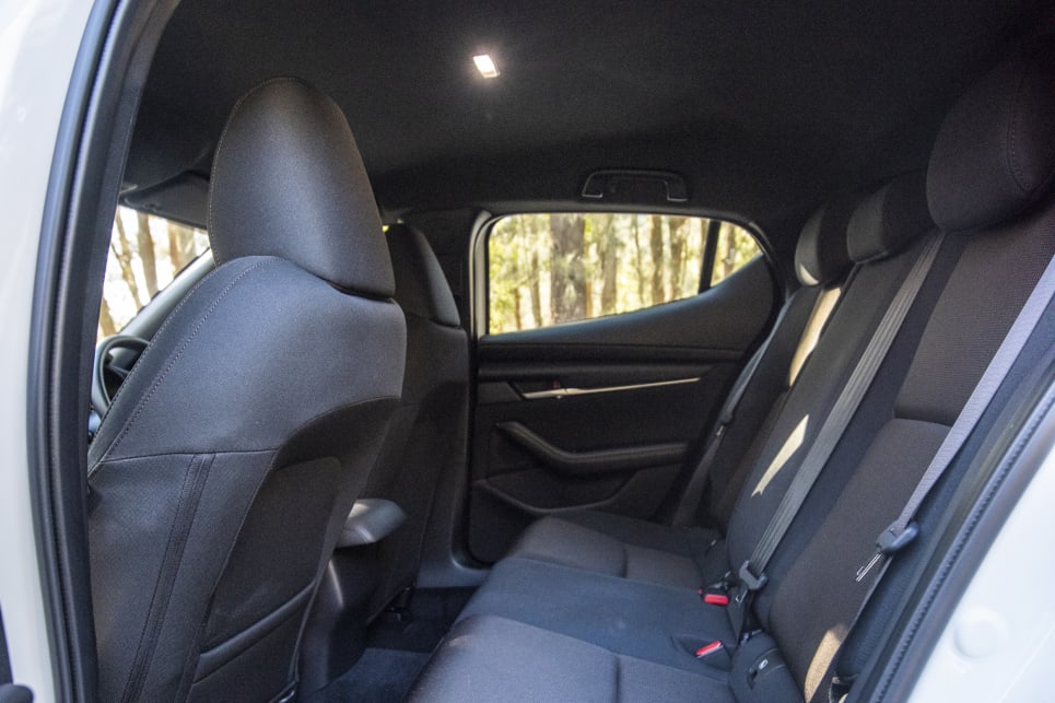 The Mazda3’s steeply raked windows and dark headlining make for a claustrophobic space for adults in the back