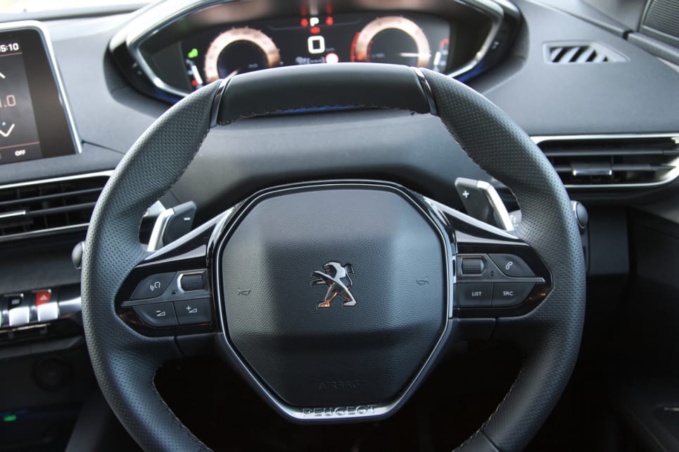 The tiny steering wheel sits low enough for you to look over its flattened rim.