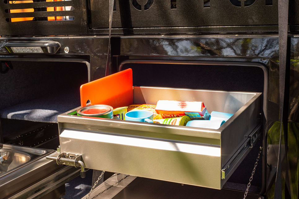 A bench-extension slides out from under the stove, and the kitchen also integrates a small drawer.
