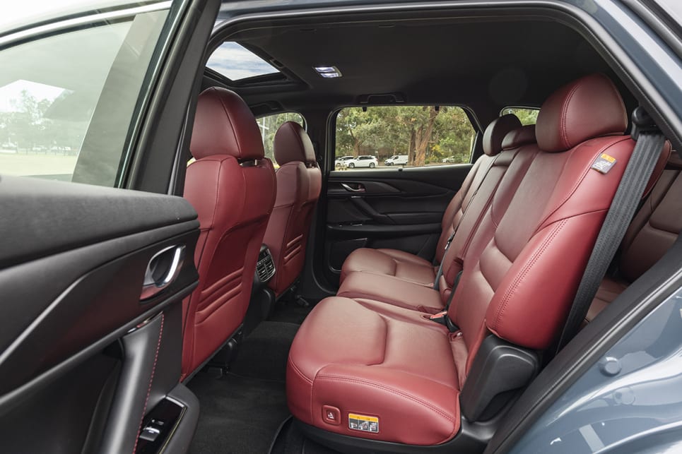 The CX-9 has a fold-down armrest in the second row which not only has cupholders but a storage space.