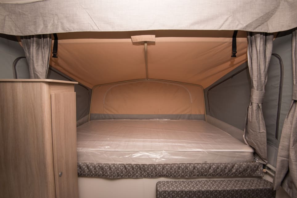 Both beds are innerspring mattresses with privacy curtains, zippered canvas windows and mesh screens. (image credit: Brendan Batty/campertrailerreview.com.au)