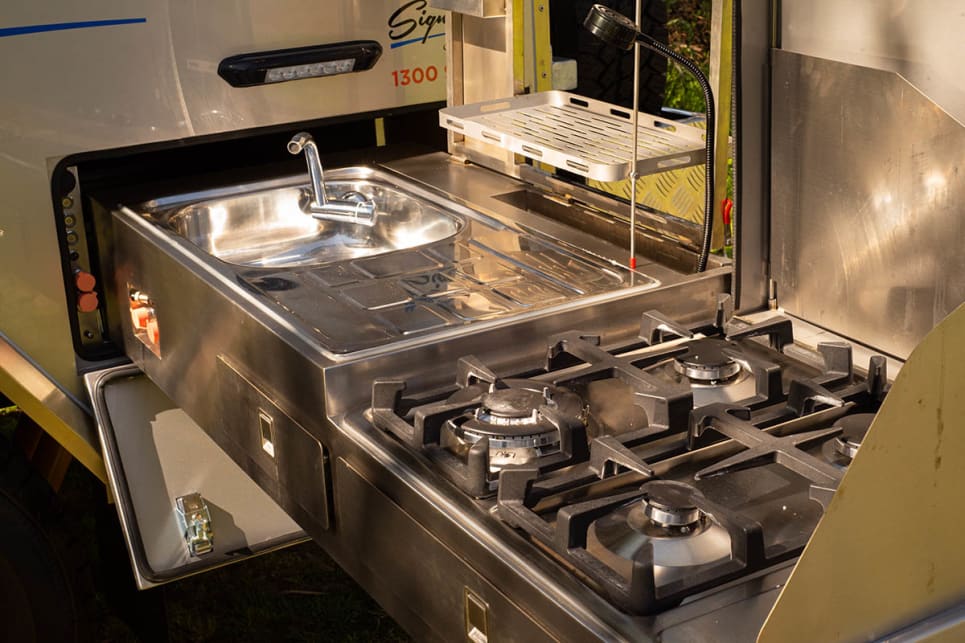 The stainless steel kitchen slides out from the back of the camper.